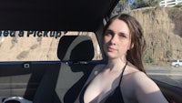 a woman in a black bikini sitting in the back seat of a car